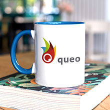 Auf einem Buch steht eine Kaffeetasse mit dem queo Logo.